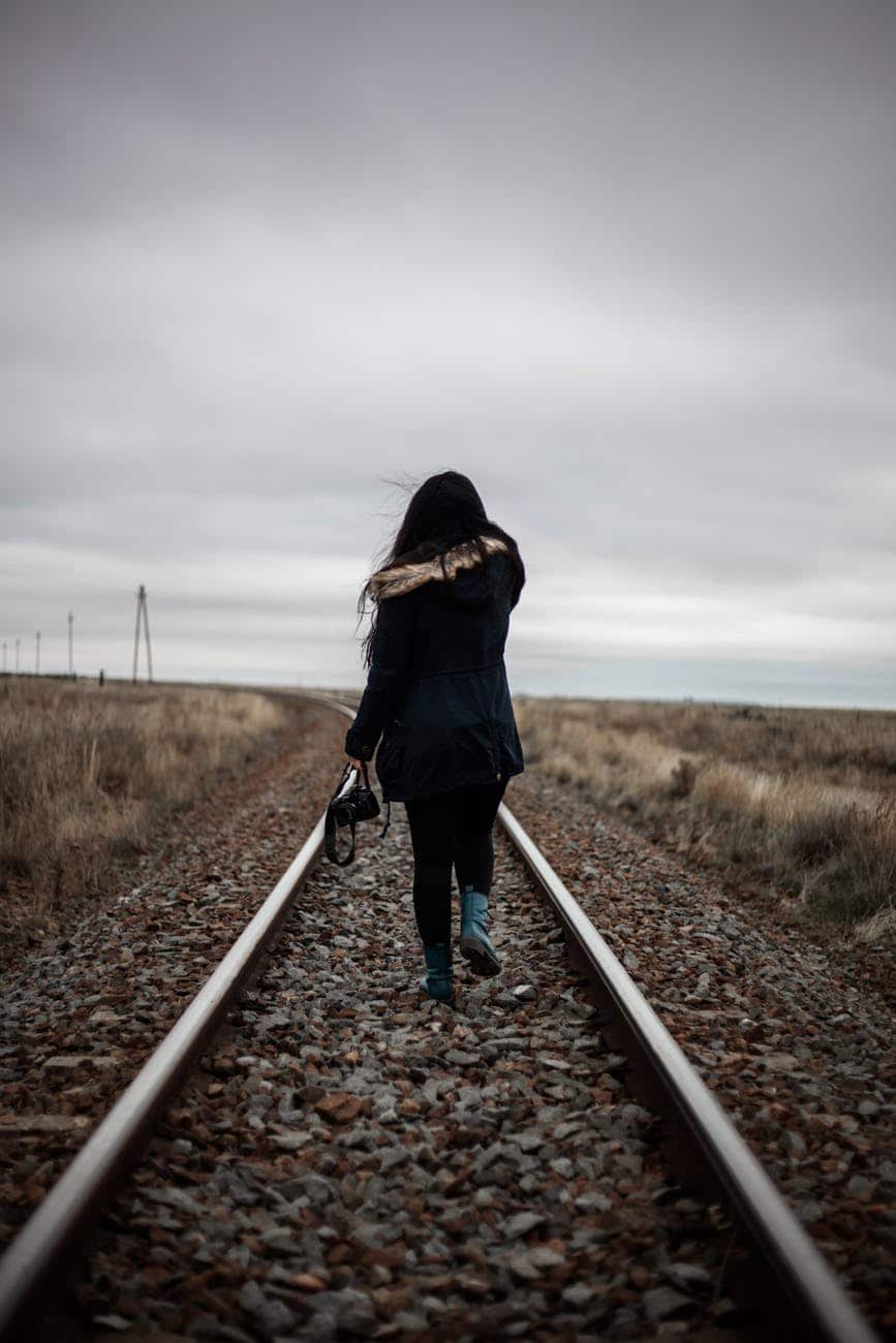 woman walking in middle of railway