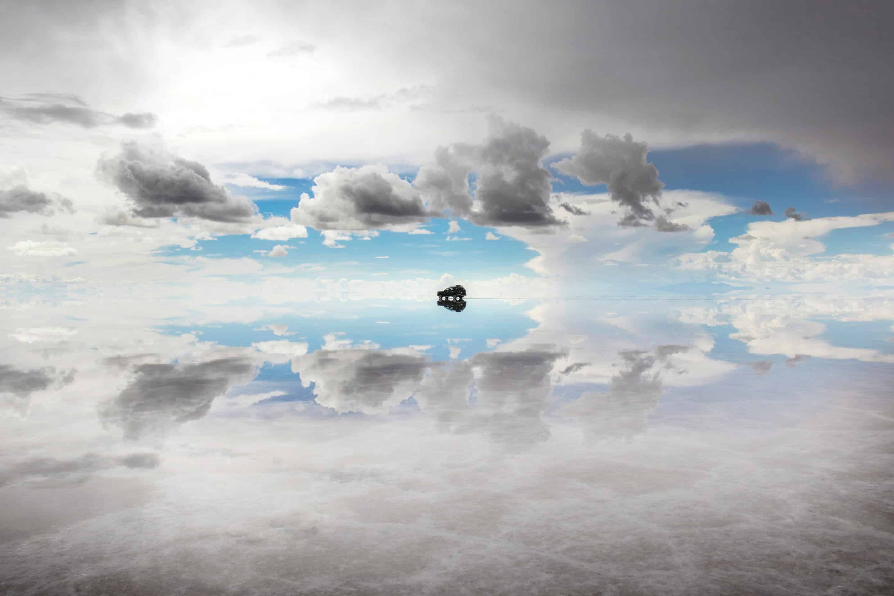 SUV reflection in water in Salar de Uyuni