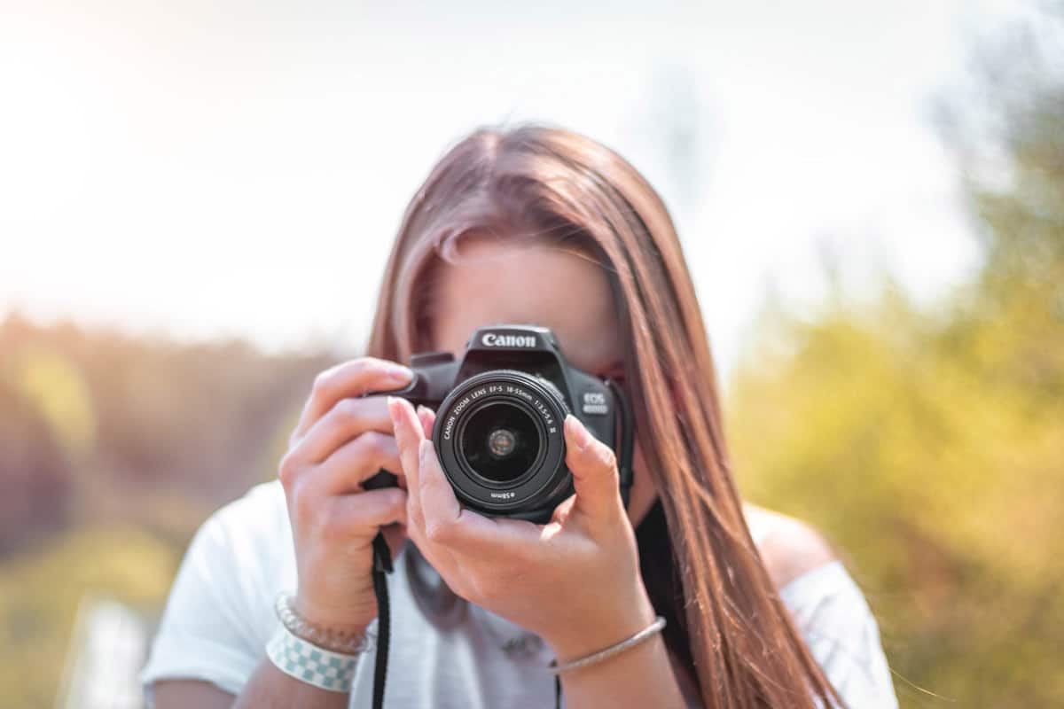 Best Canon lenses for landscapes - a woman composing a photo with a camera.