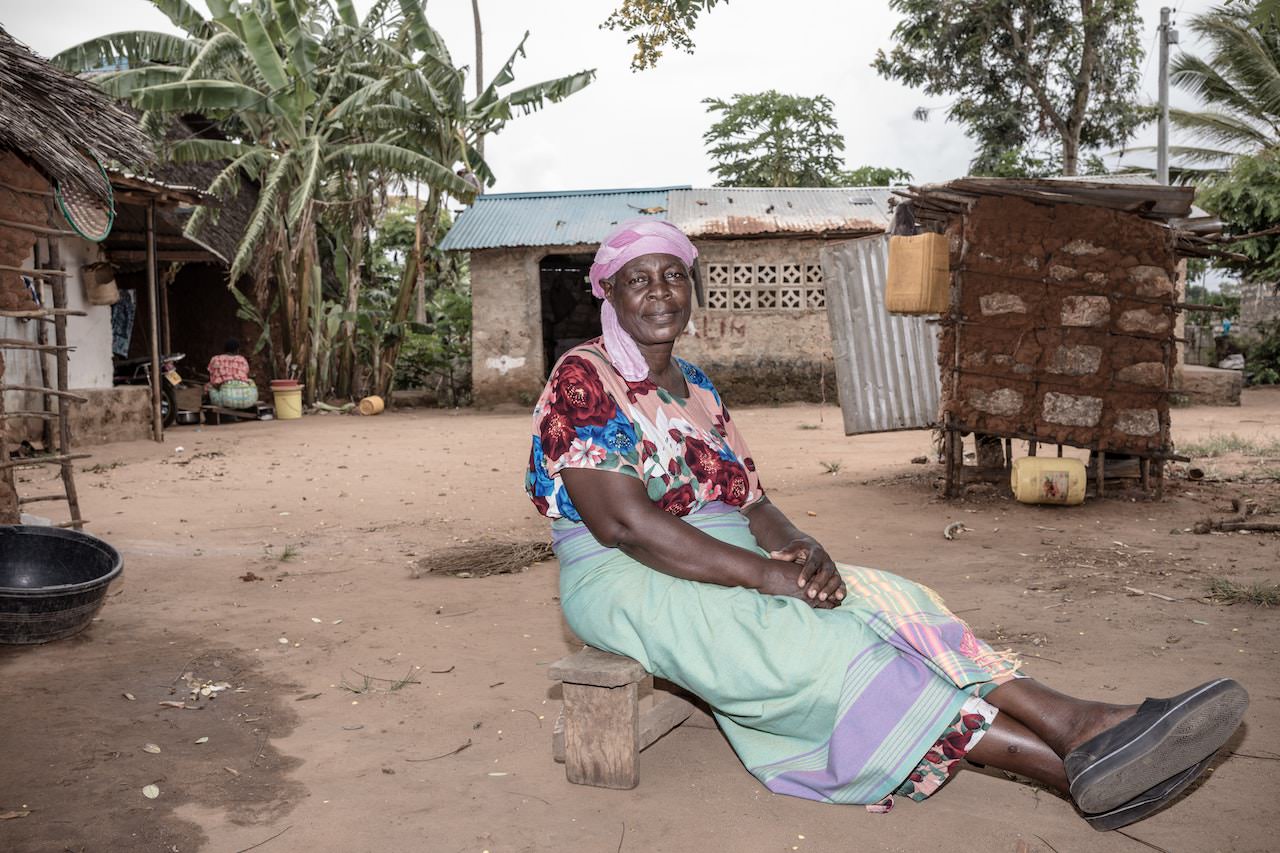 Best cameras for photojournalism. Elderly woman sits in the village.