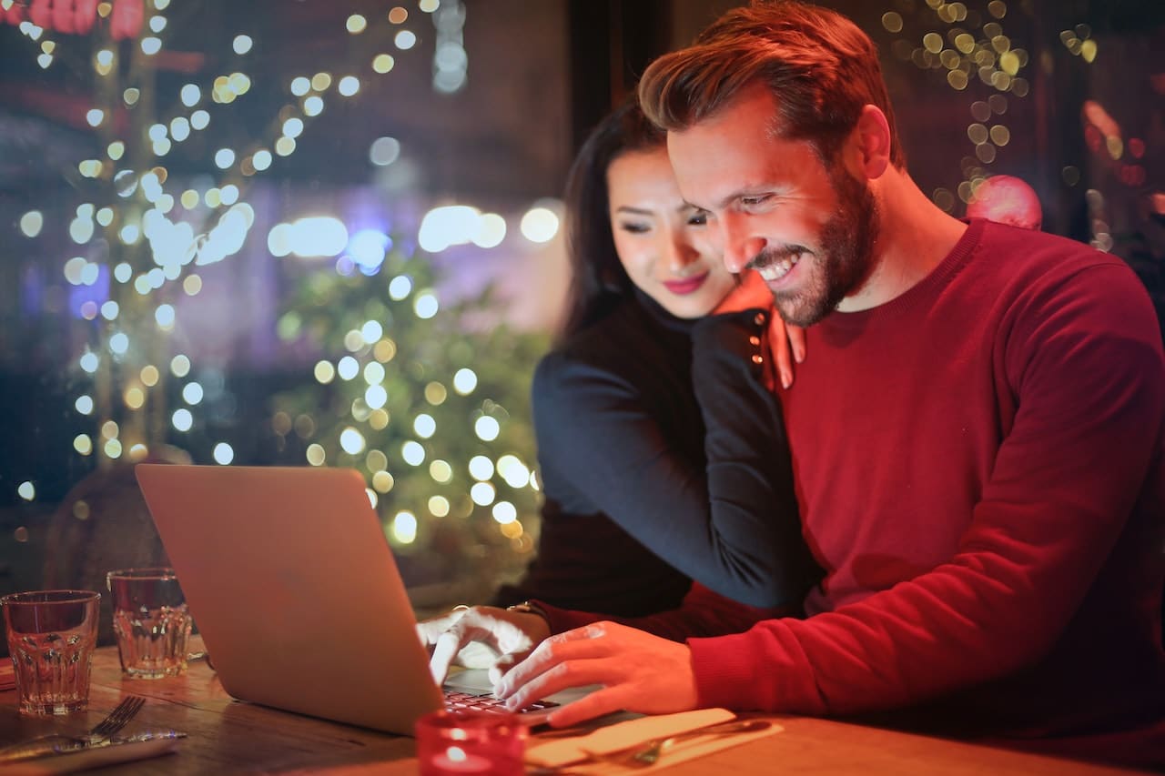 happy couple using a laptop during the holidays